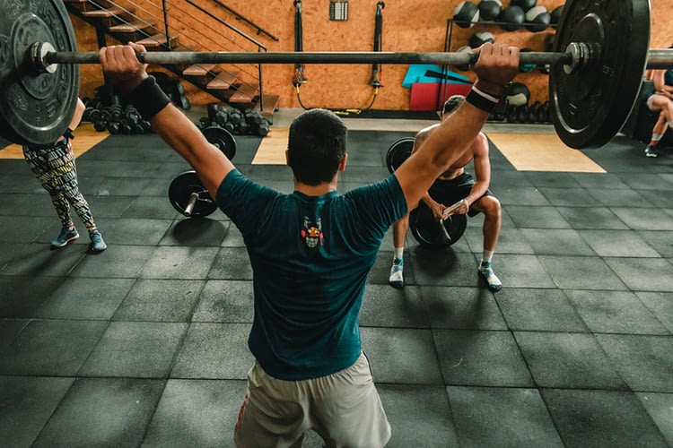 sportif levant un haltère au-dessus de sa tête